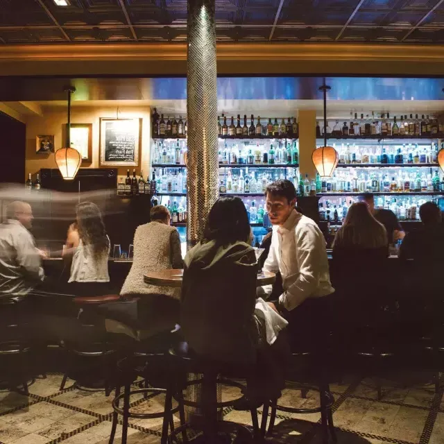 Un couple partage des boissons dans un bar animé de San Francisco.